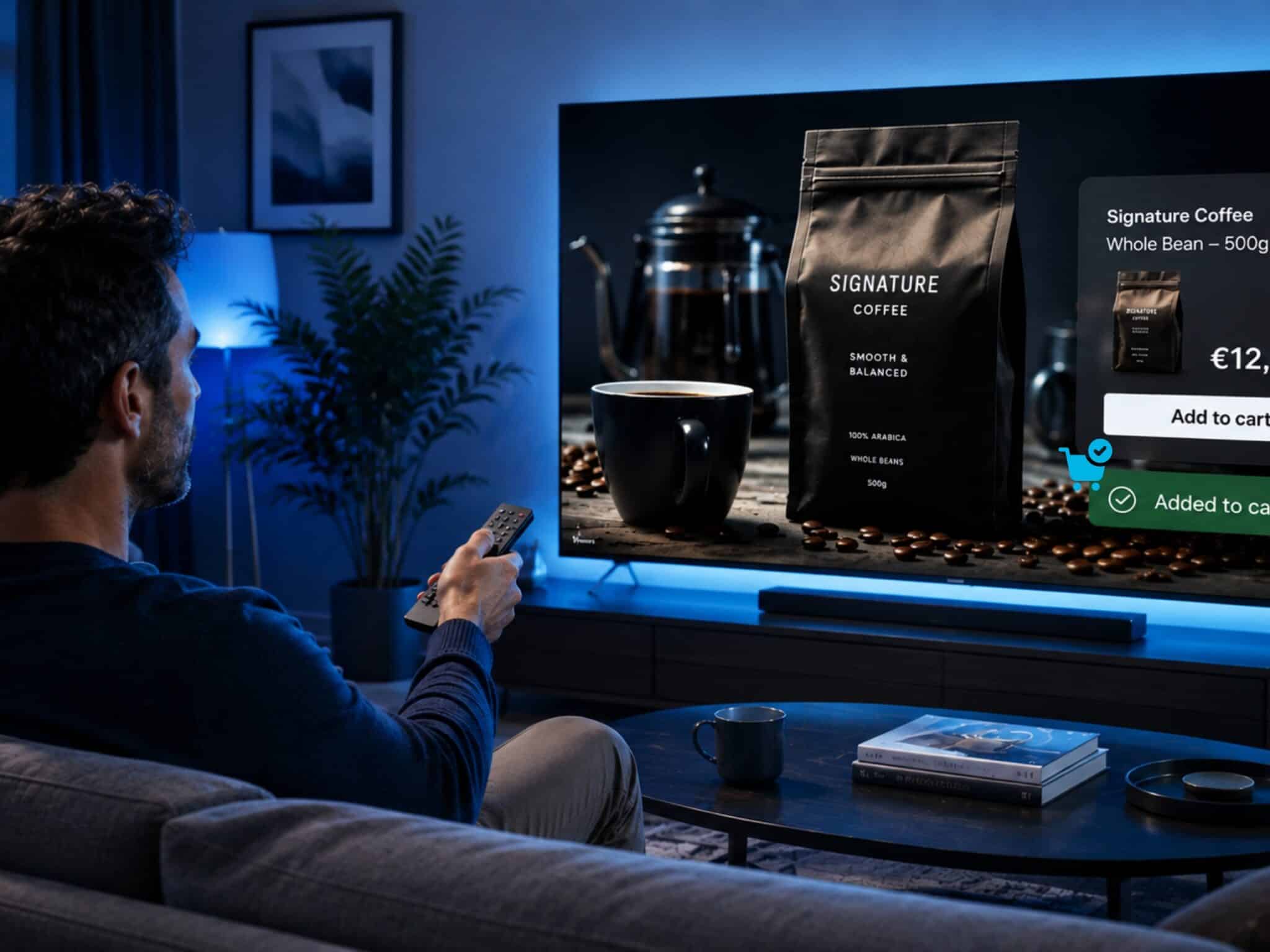 A man sits on a sofa in a blue-lit living room, using a TV remote to interact with a shoppable Connected TV coffee advertisement featuring an “Add to cart” option and purchase confirmation.